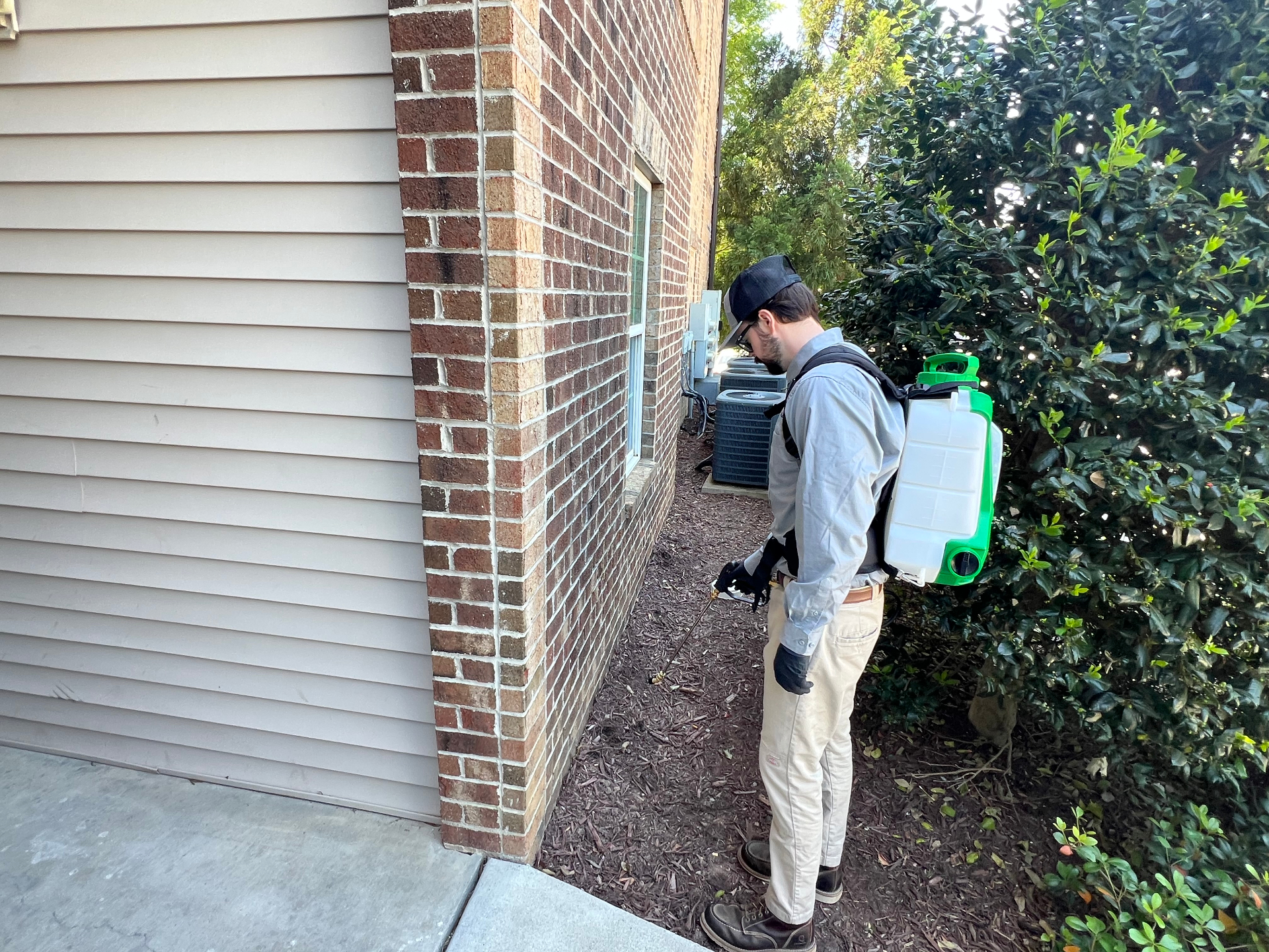 Eradicare technician treating a home exterior